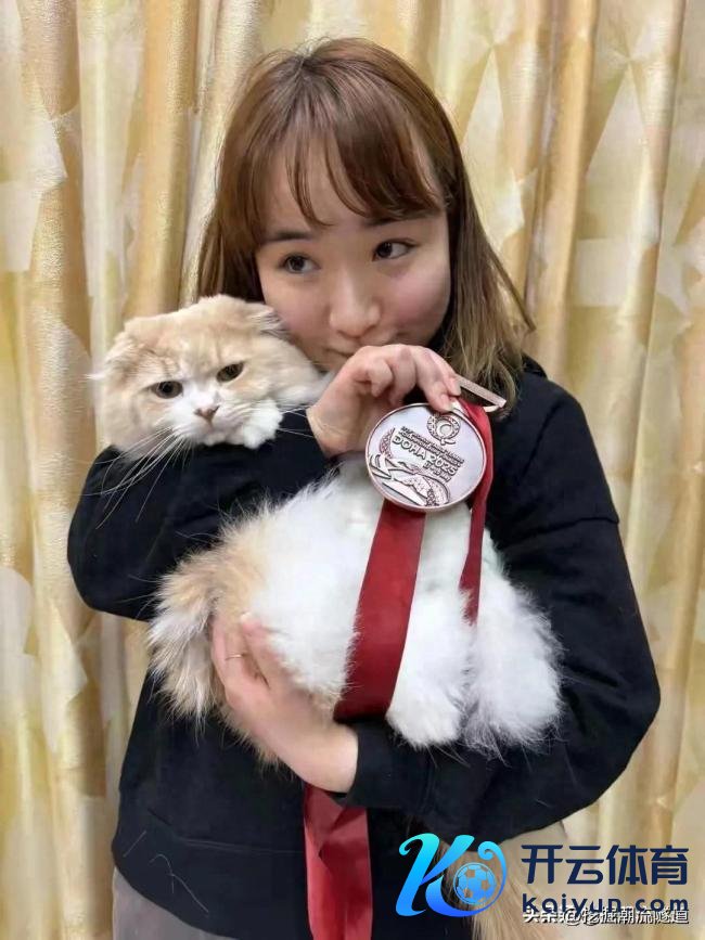伊藤好意思诚拿着多哈世乒赛铜牌和家里的猫咪合影